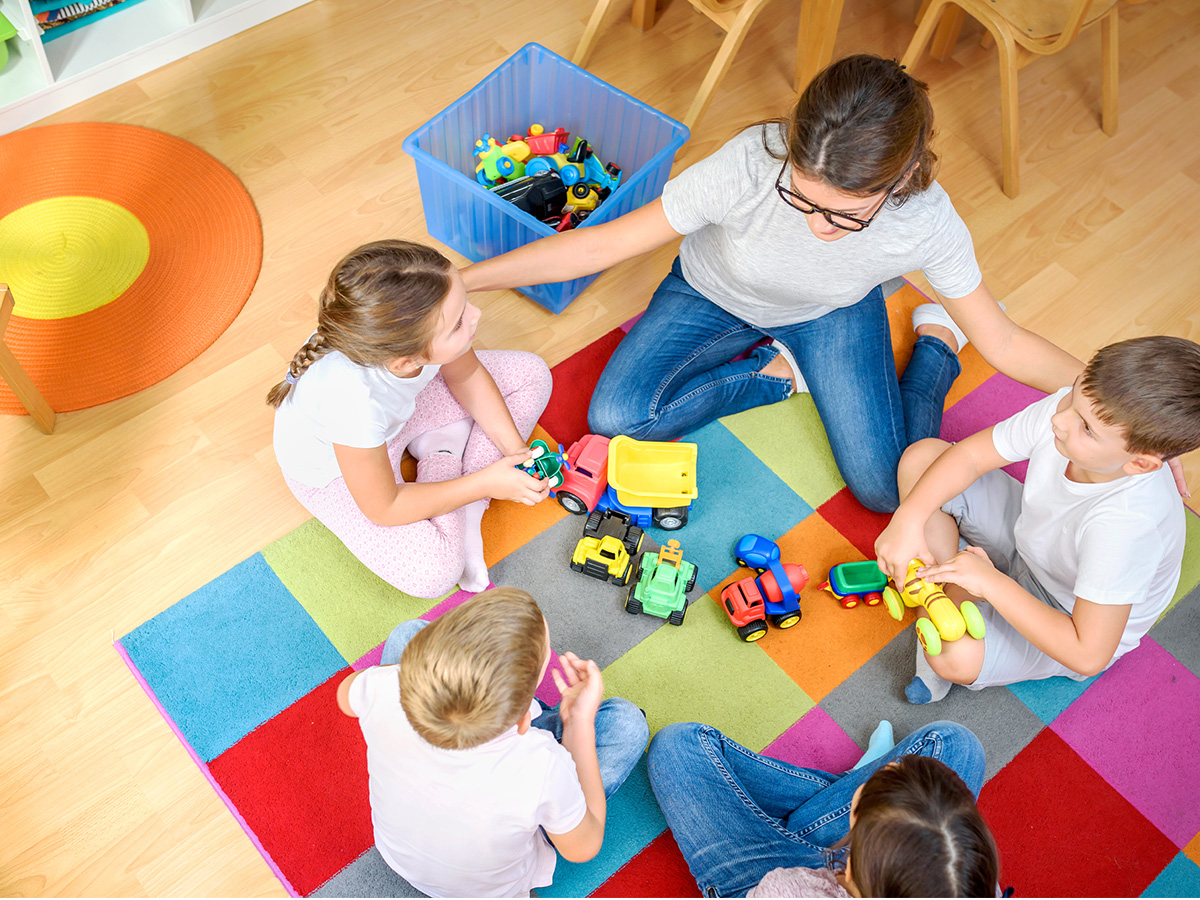 children gathered around teacher