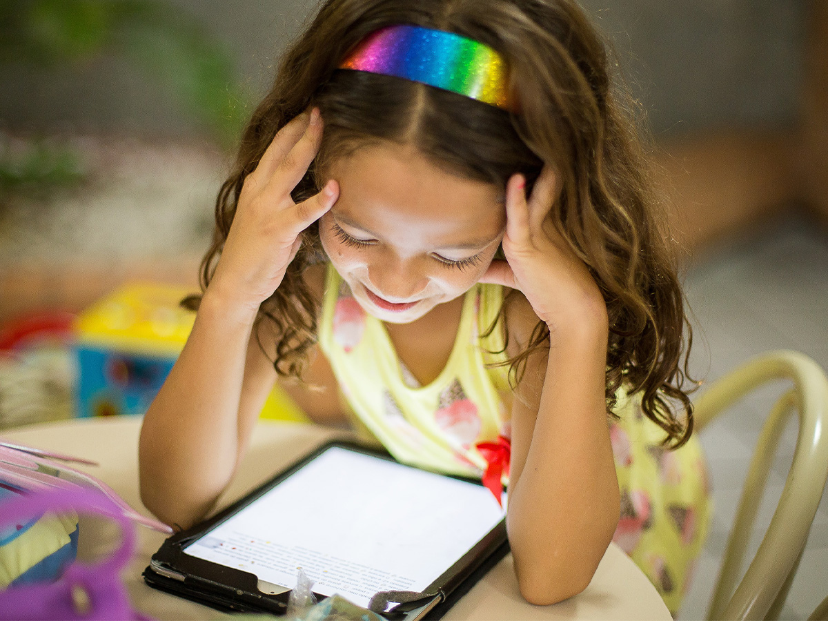 young child reading on mobile tablet