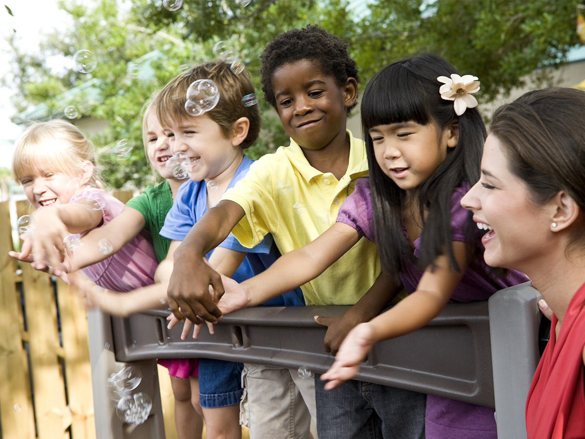 diverse group of kids playing on outdoor playground