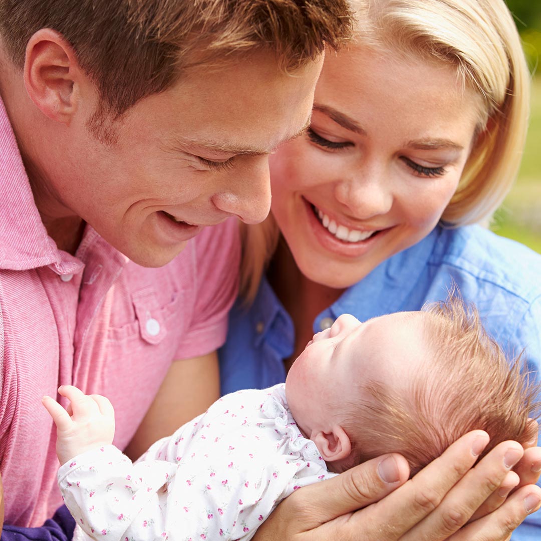 Happy mother and father holding baby