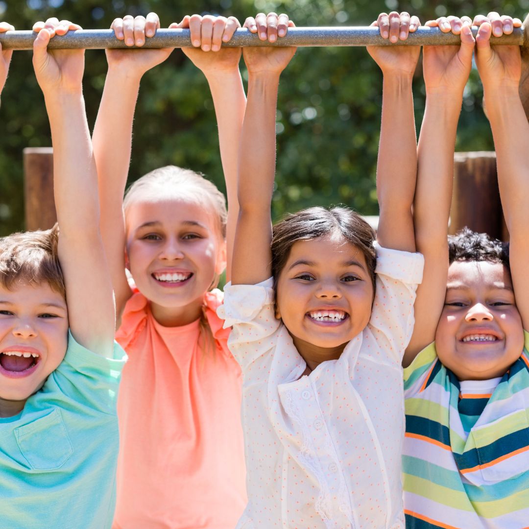 kids hanging from monkey bars