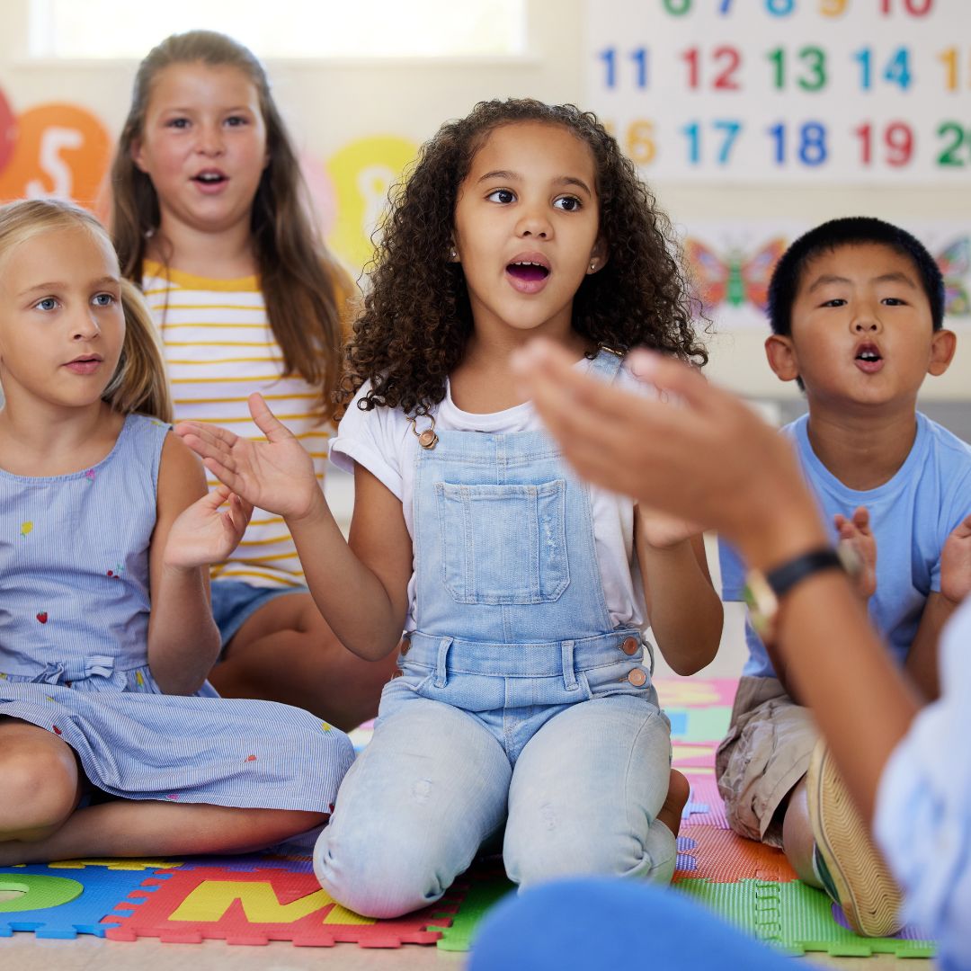 School aged children clapping and signing along to song