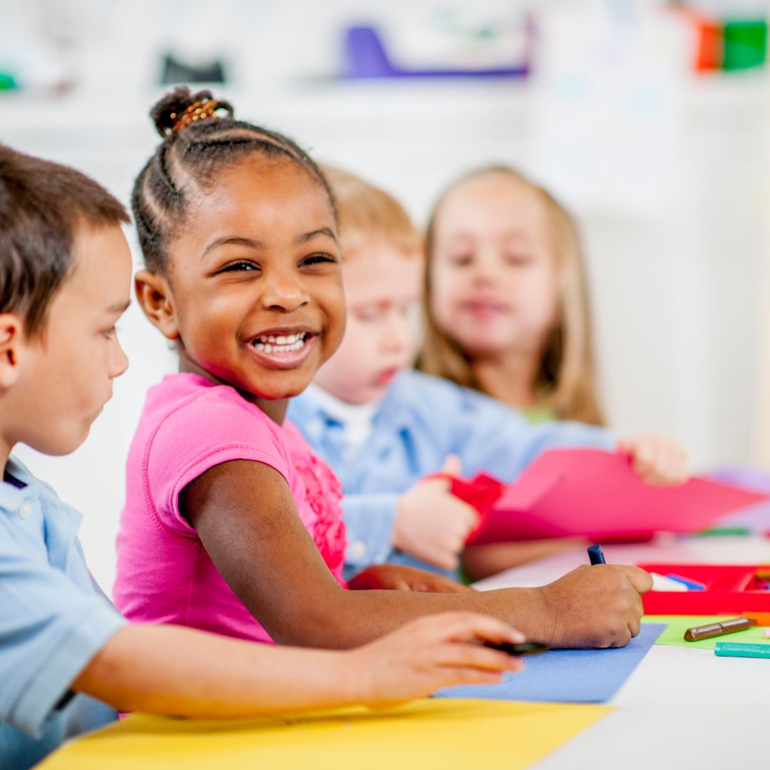 a little girl smiling while doing crafts
