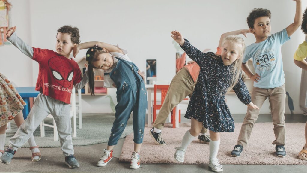 kids stand side by side and do stretches