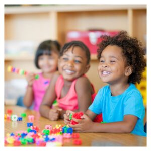 kids sit at a table in a classroom 