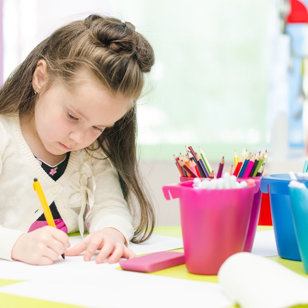 girl coloring at table
