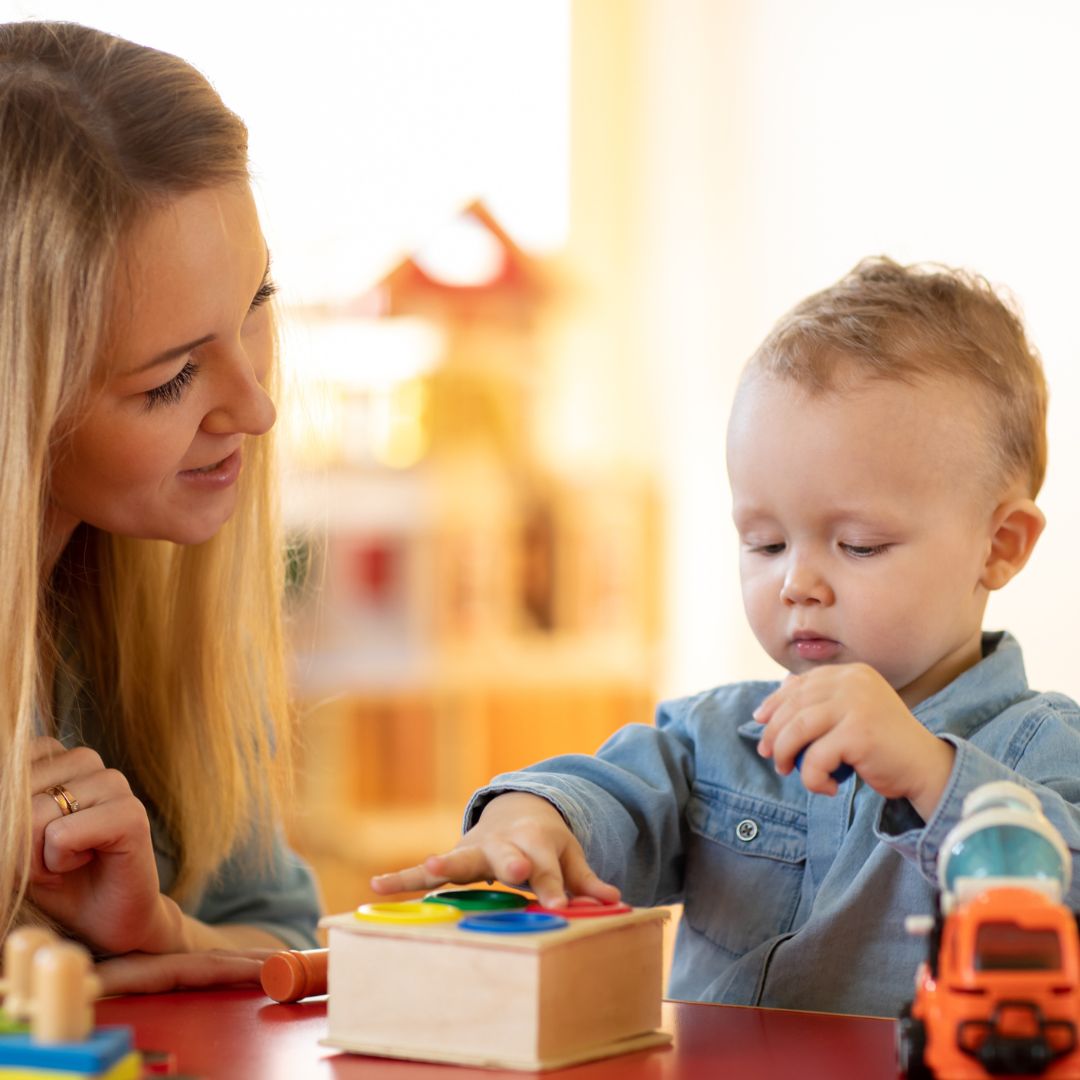little boy playing with toys with mother
