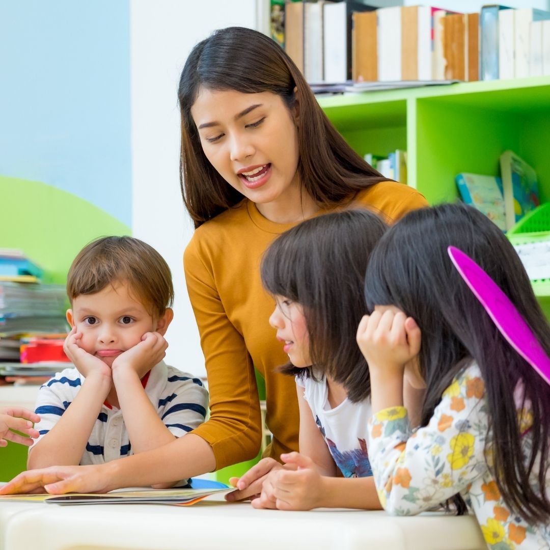 A teacher reading to toddlers.