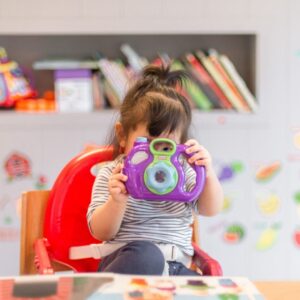little girl holding a toy camera